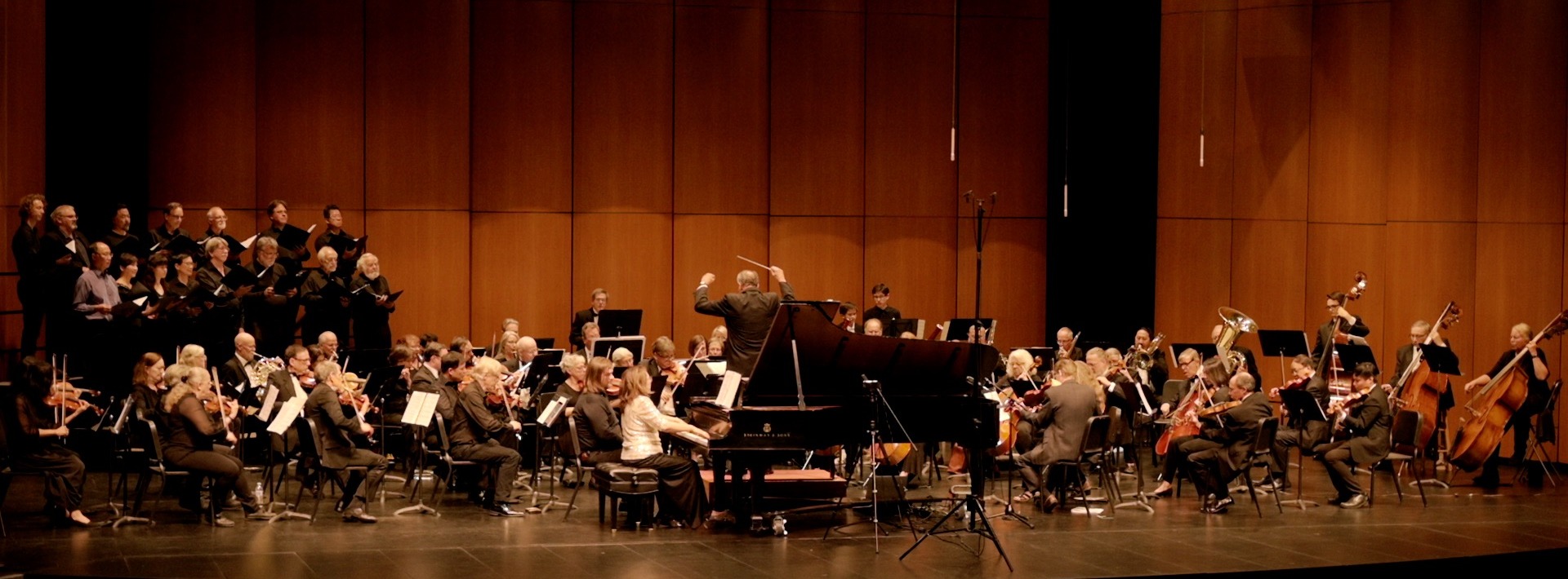 Saratoga Symphony orchestra, choir, and piano soloist performing on stage